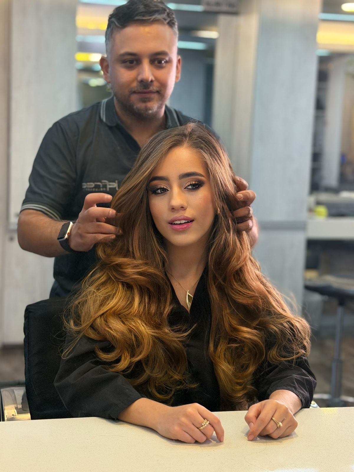 Jefree peinando a una clienta con balayage caramelo en su salón